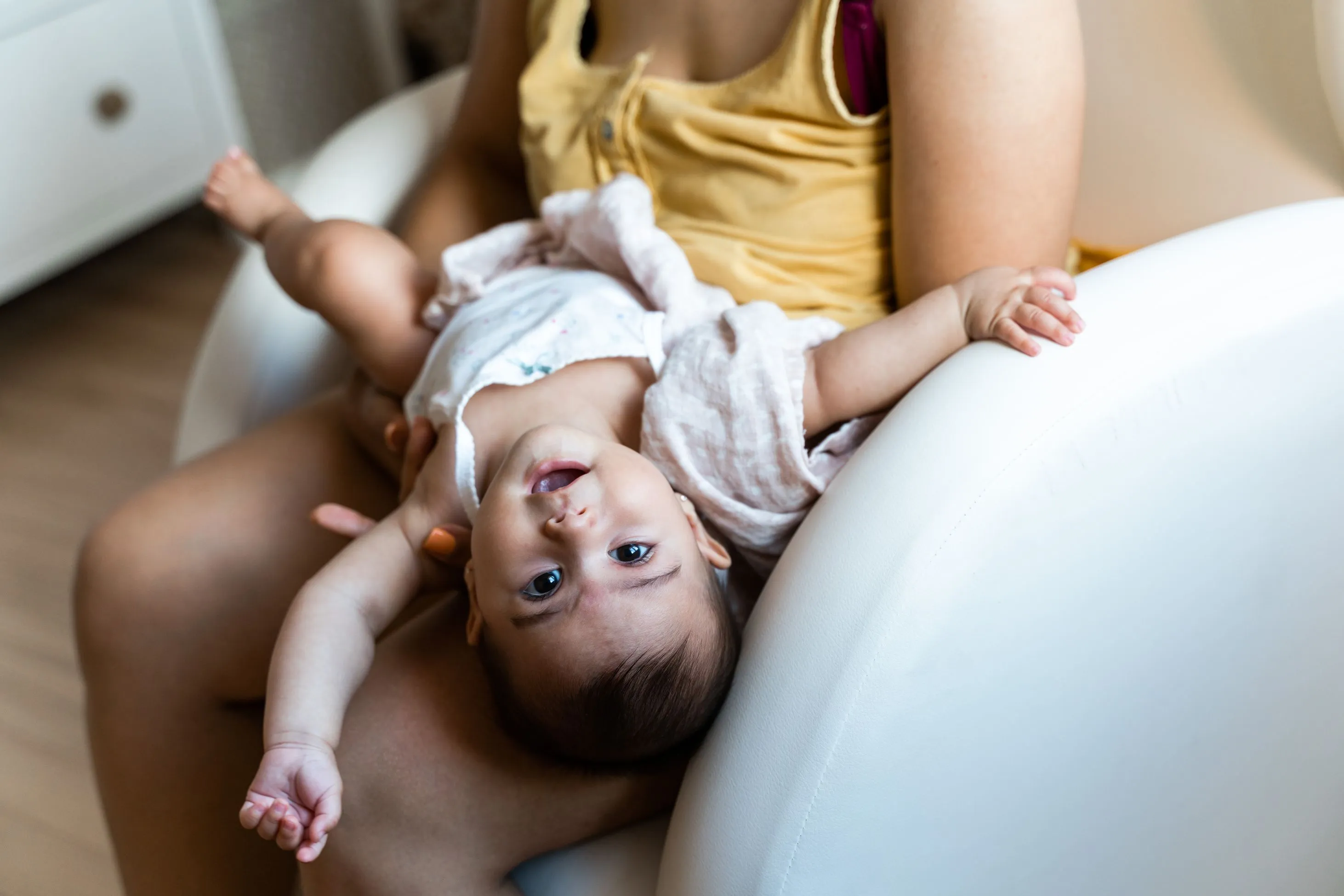 baby on mother's lap playing upside down