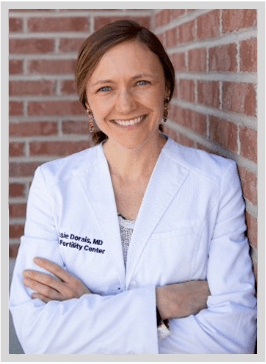 Dr. Jessie Dorais, leaning against a brick wall smiling